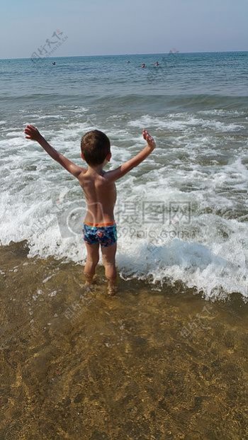站在海边的小男孩